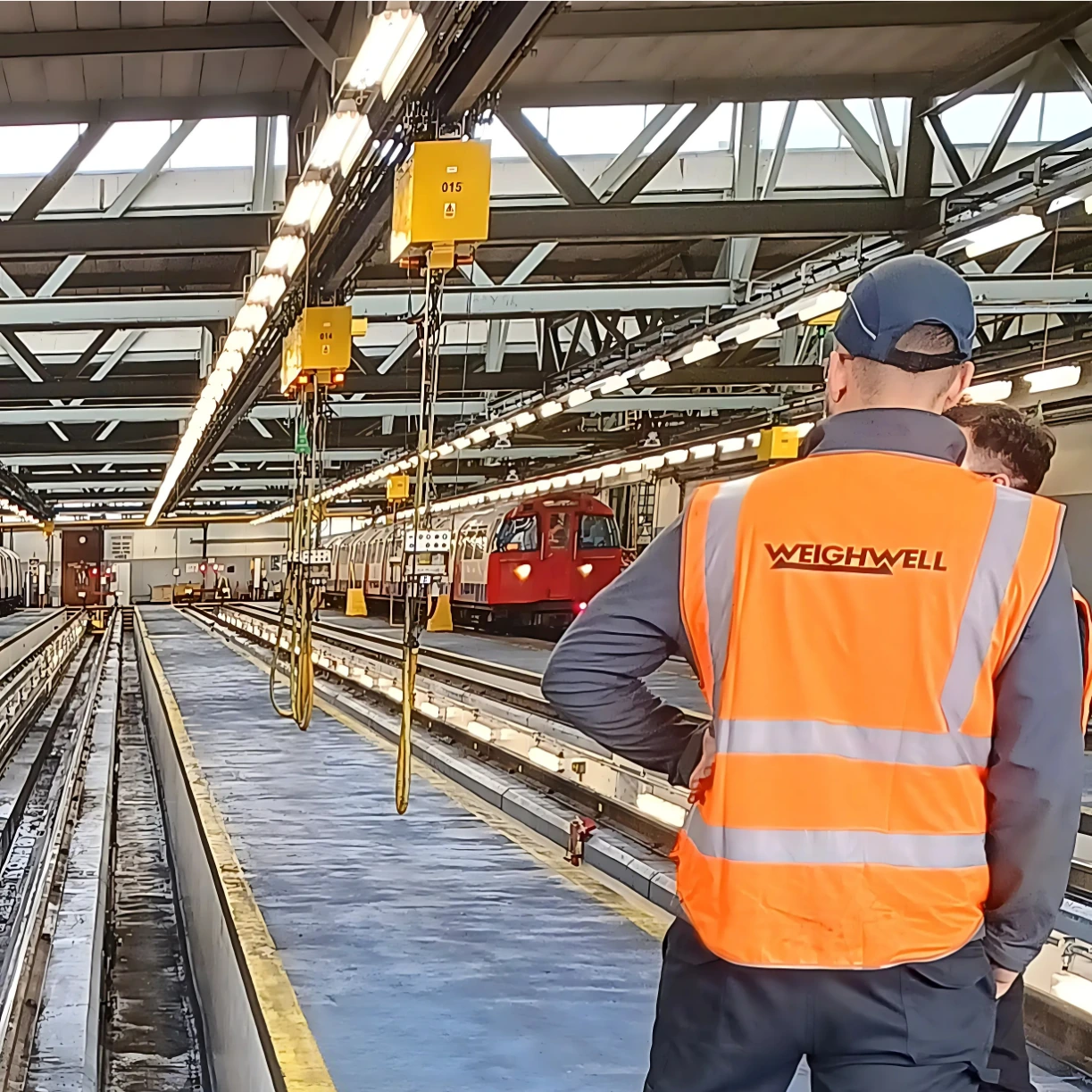 Technician standing in front of rolling stock inside London Underground depot Technician standing in front of rolling stock inside London Underground depot