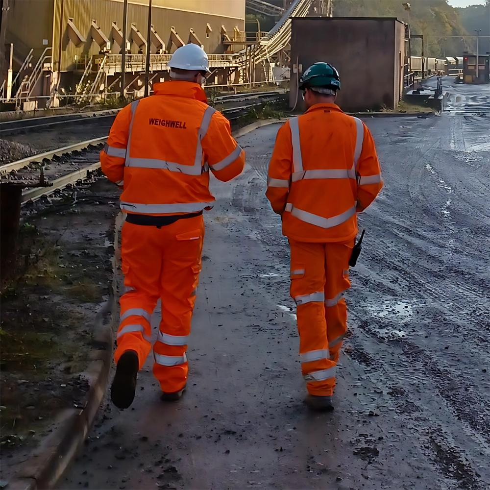Weighwell technician with customer, both wearing PPE, inspecting a potential weighing location